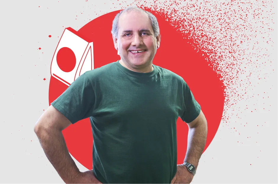 Ein lächelnder Mitarbeiter in einem grünen T-Shirt steht selbstbewusst vor rotem Hintergrund in der Lebensmittelbranche.