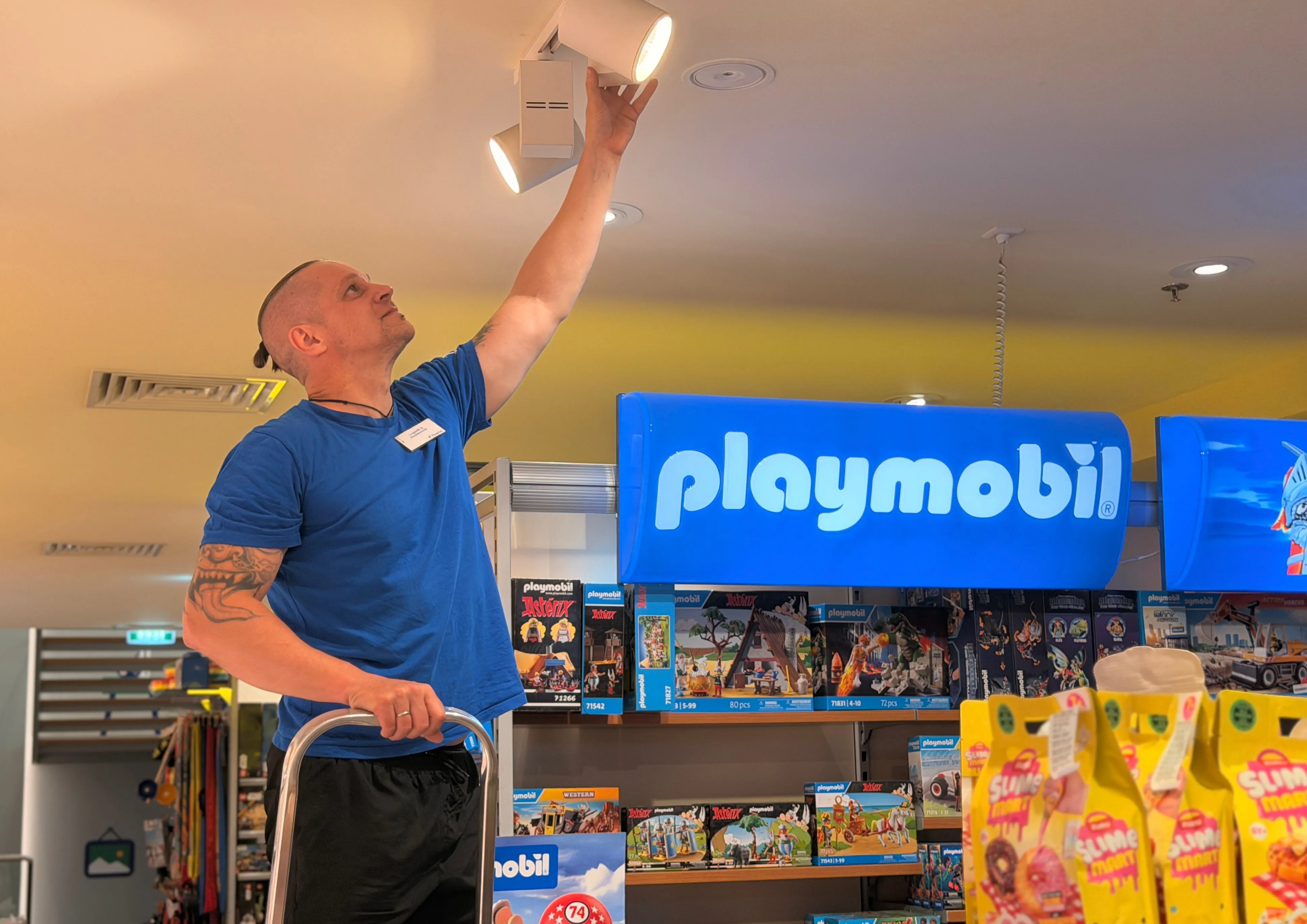 Sechs junge Menschen stöbern gemeinsam in Büchern bei Thalia, umgeben von bunten Buchregalen und gemütlicher Atmosphäre.