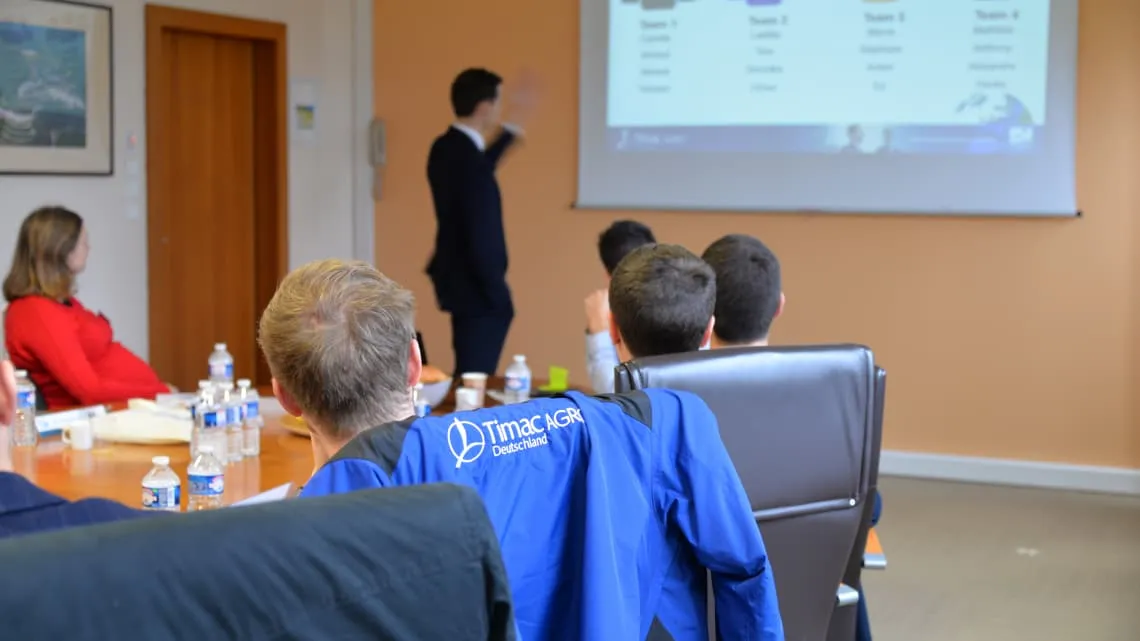 Du siehst ein Team-Meeting bei TIMAC AGRO Deutschland, bei dem ein Kollege eine Präsentation hält.