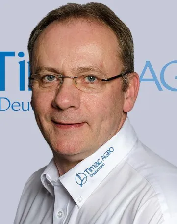 Ein Mitarbeiter von TIMAC AGRO Deutschland mit Firmenhemd schaut freundlich in die Kamera.