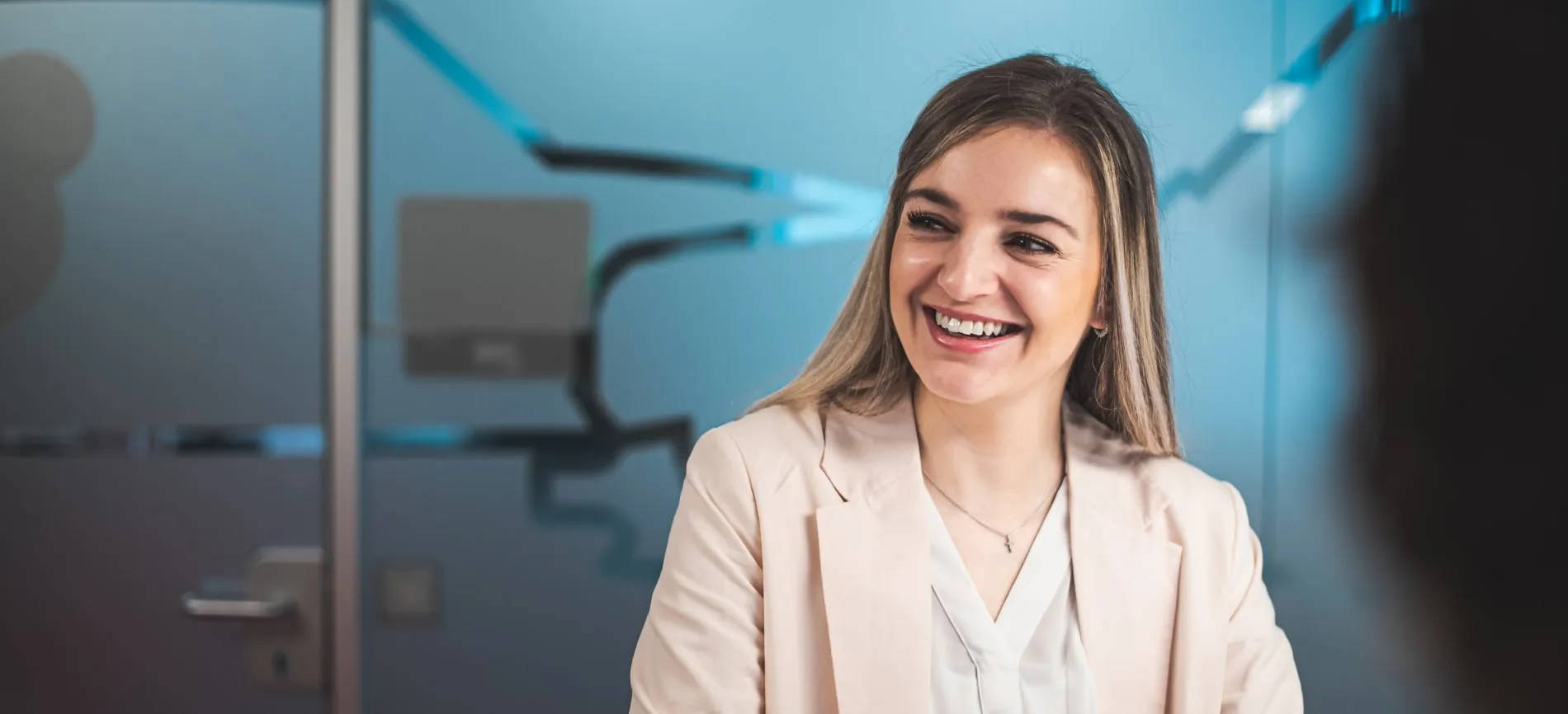 Junge Frau im Business-Outfit lächelt freundlich in einem modernen Büro bei Toyota Deutschland.