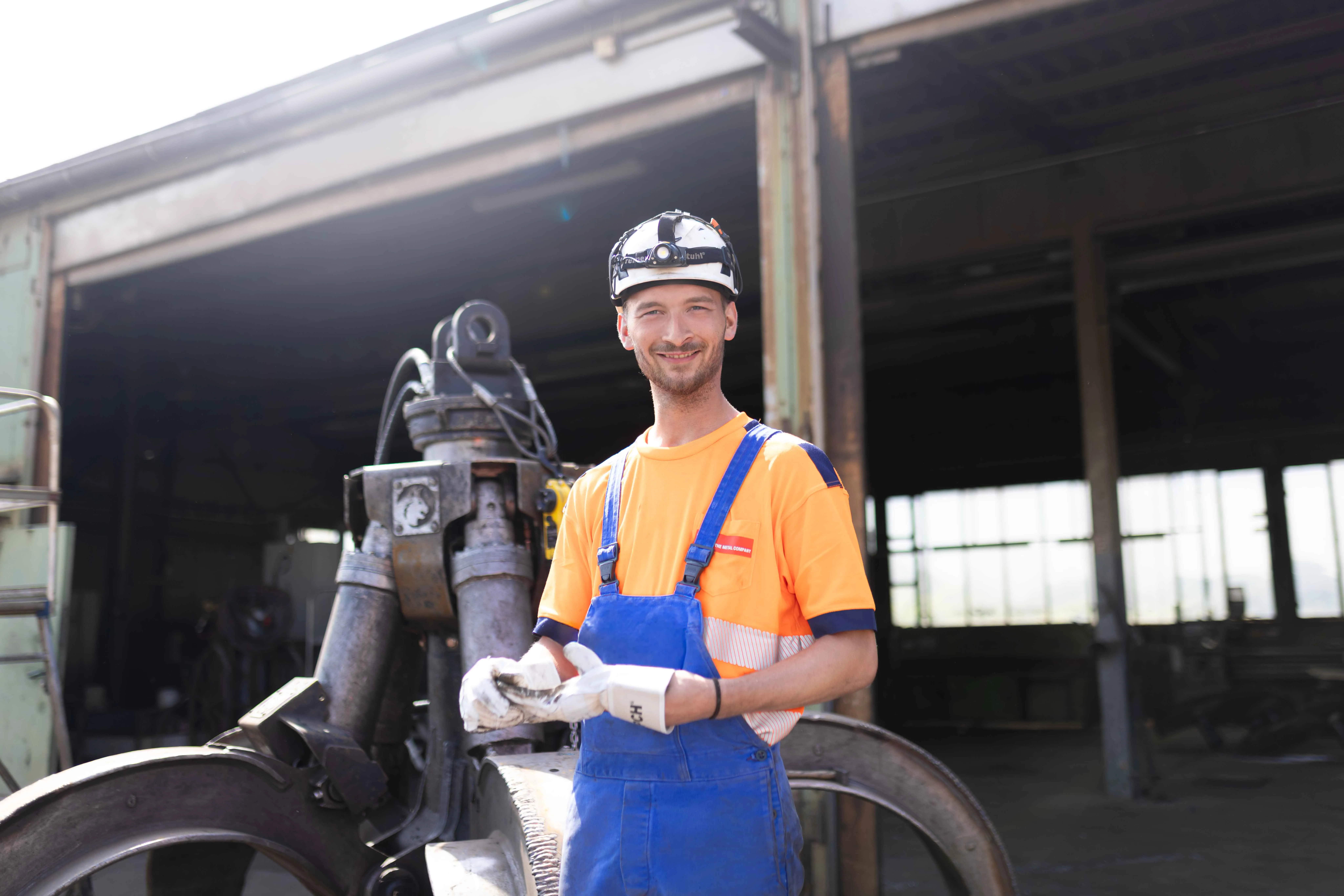 Mitarbeiter in Arbeitskleidung zieht Handschuhe an
