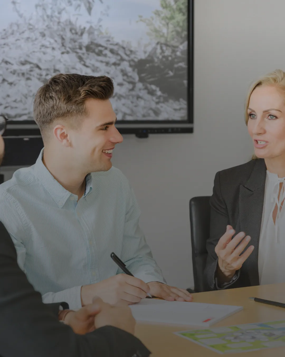Zwei Kollegen im Gespräch bei TSR Group, diskutieren Projekte.