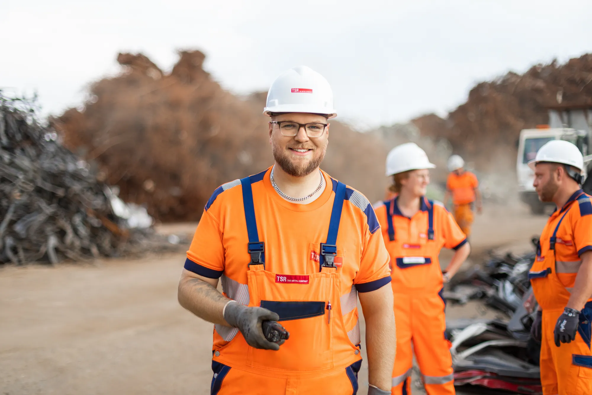 Mitarbeitende in Arbeitskleidung auf dem Betriebsgelände