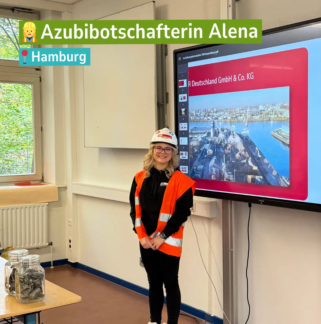 Azubibotschafterin Alena von TSR Group steht mit Sicherheitsweste und Helm vor einer Präsentation in einer Schule in Hamburg.