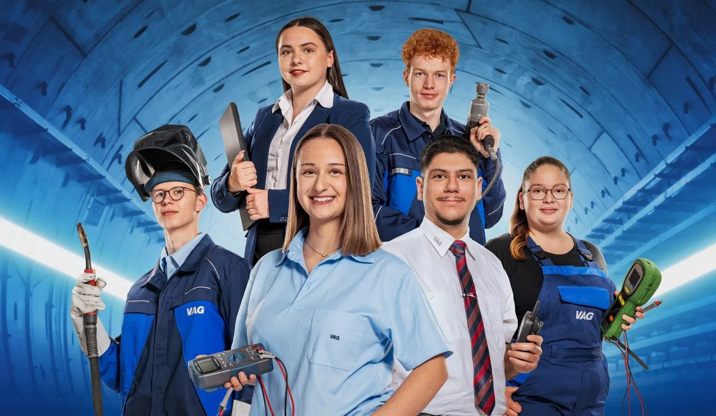 Vier junge Fachkräfte in Arbeitskleidung stehen in einem Tunnel und repräsentieren die Karrierechancen bei VAG Verkehrs-Aktiengesellschaft.