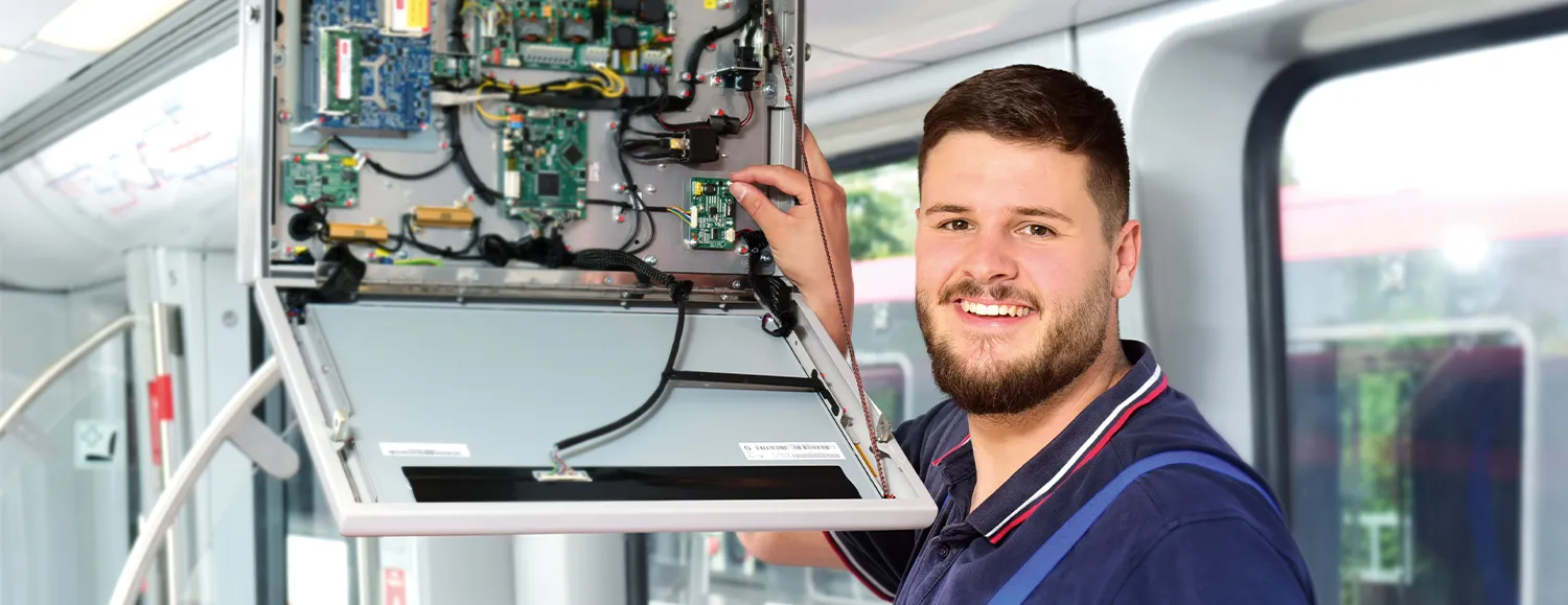 Ein junger Techniker in blauer Arbeitskleidung wartet einen Aufzug an einer Haltestelle der VAG. Du kannst hier mitgestalten.