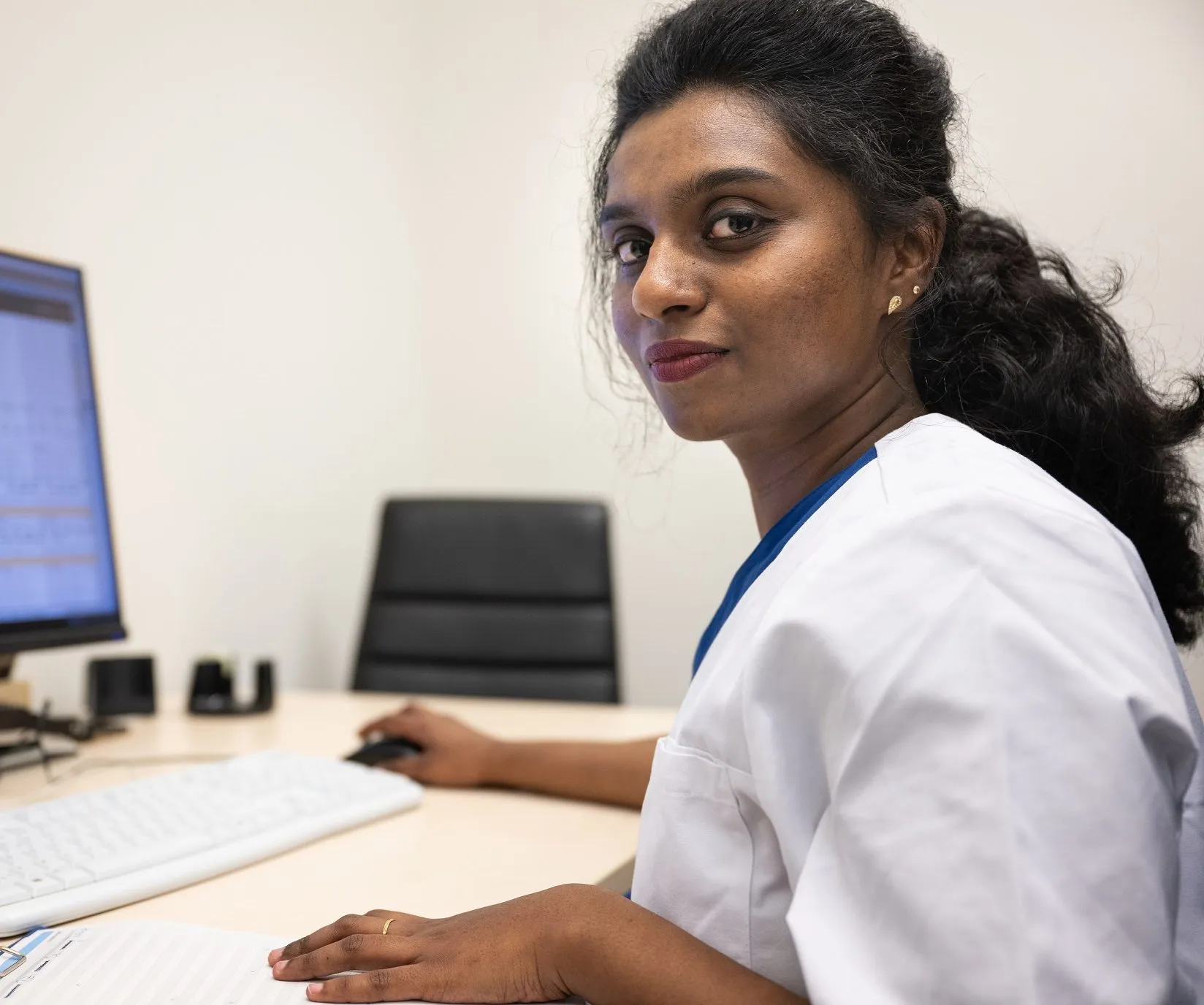 Pflegefachkraft Merin am Stationscomputer