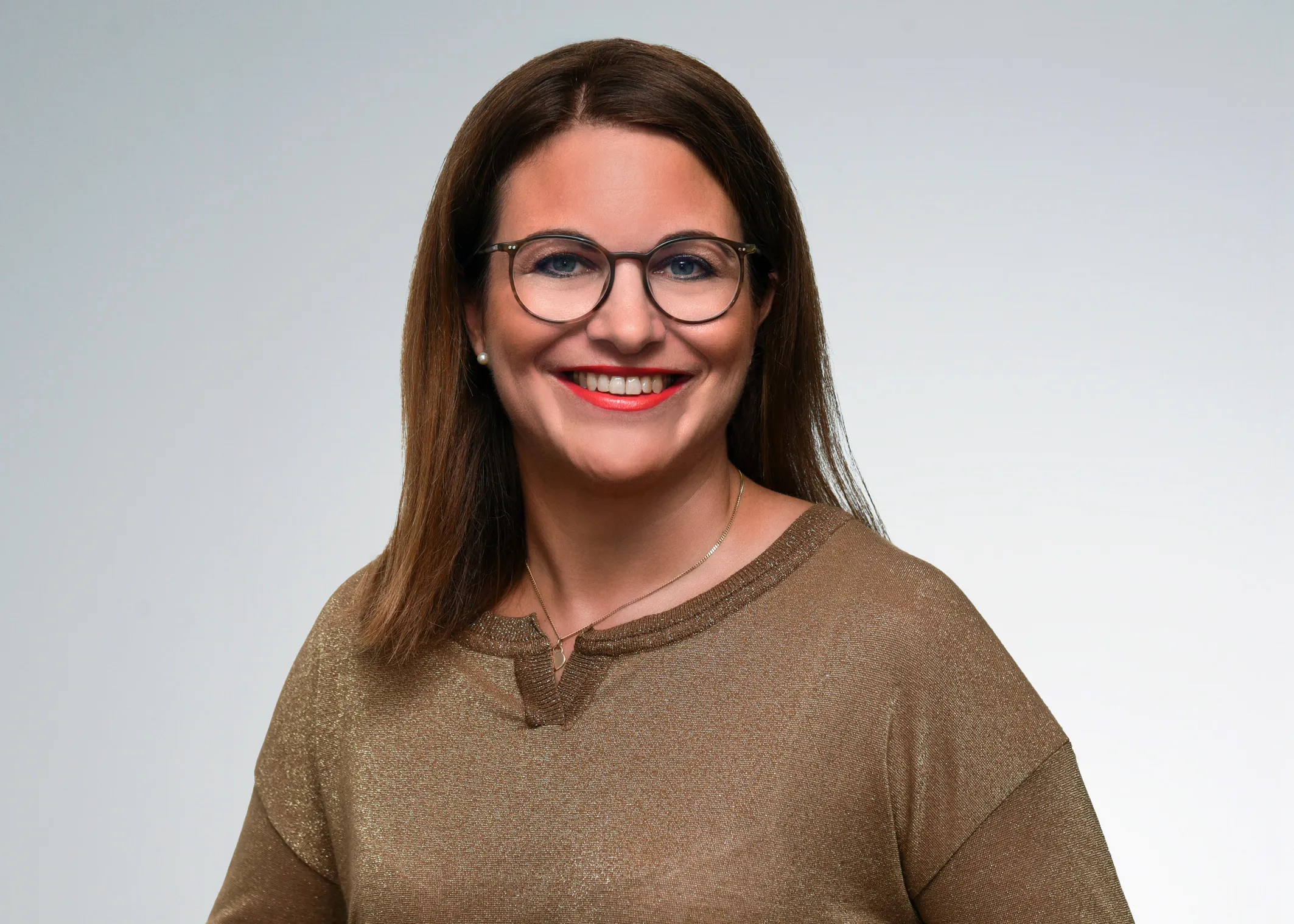 Freundliche Bankmitarbeiterin mit Brille lächelt im Porträt, bereit, Dich bei Deiner Karriere bei der VR Bank zu unterstützen.