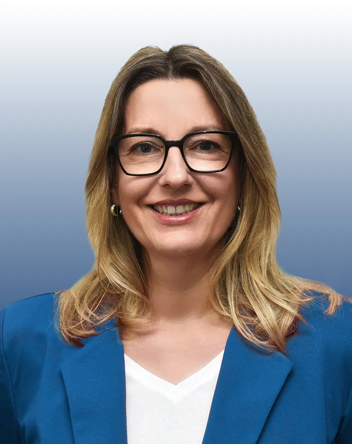 Freundliche Bankmitarbeiterin im blauen Blazer, die Dich auf der Karriereseite der VR Bank begrüßt.
