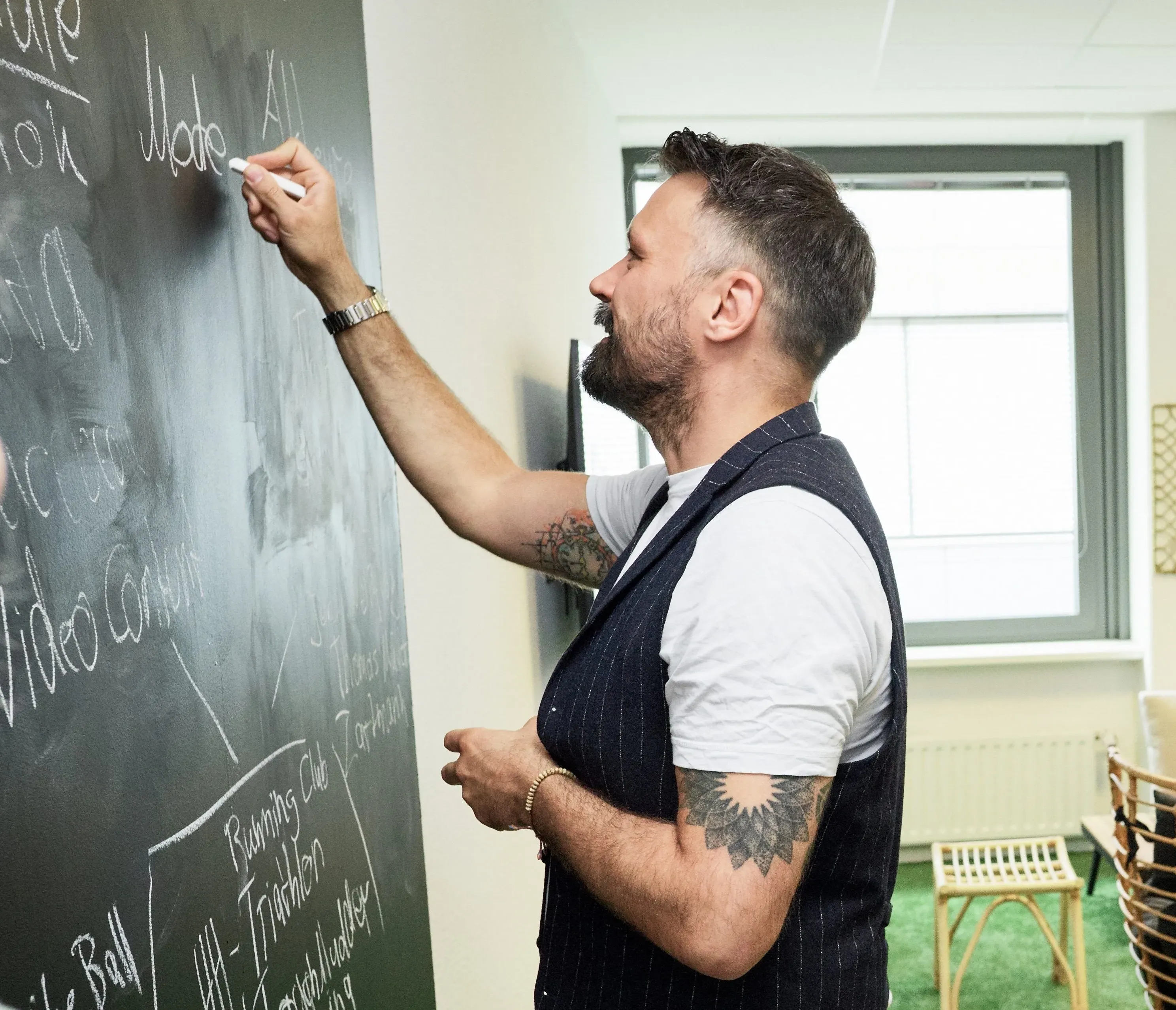 Zwei Männer in einem modernen Büro bei Walbusch Walter Busch GmbH & Co. KG, die sich über einen Bildschirm unterhalten.