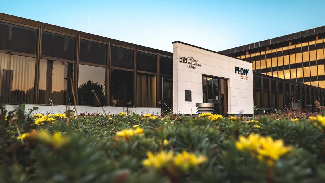 Modernes Firmengebäude von Westfalen Weser Netz mit Blumenbeet im Vordergrund bei Tageslicht.