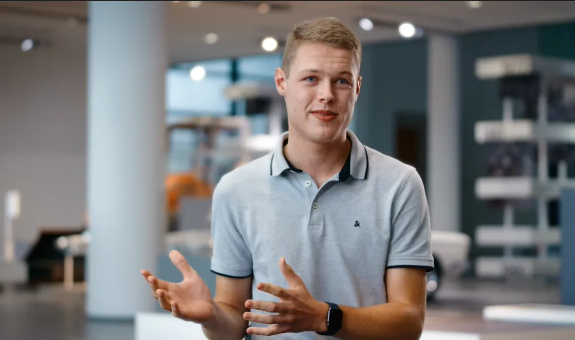 Junger Mitarbeiter von ZF Friedrichshafen AG spricht offen und freundlich in einem modernen Büro über Karrierechancen in der Automobilbranche.