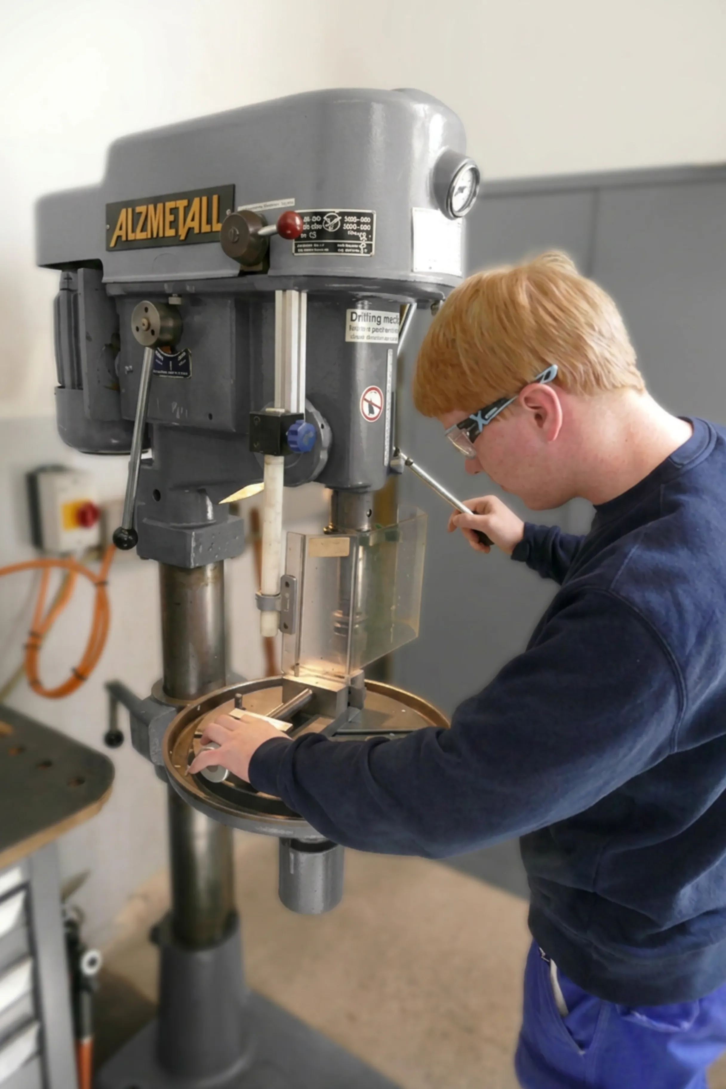 Vier junge Auszubildende bei ZF Friedrichshafen AG präsentieren stolz ihre technischen Projekte in einer modernen Werkstatt.
