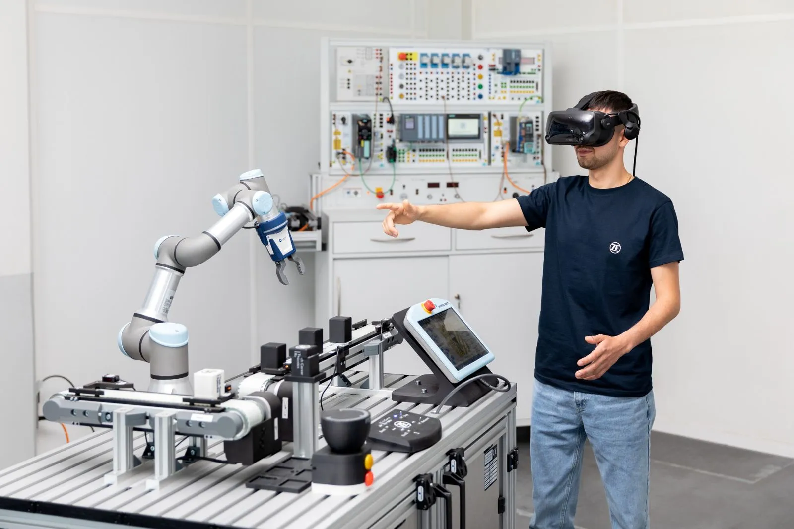 Du steuerst einen Roboterarm mit VR-Brille im modernen Labor von ZF Friedrichshafen AG für Automotive-Innovationen.
