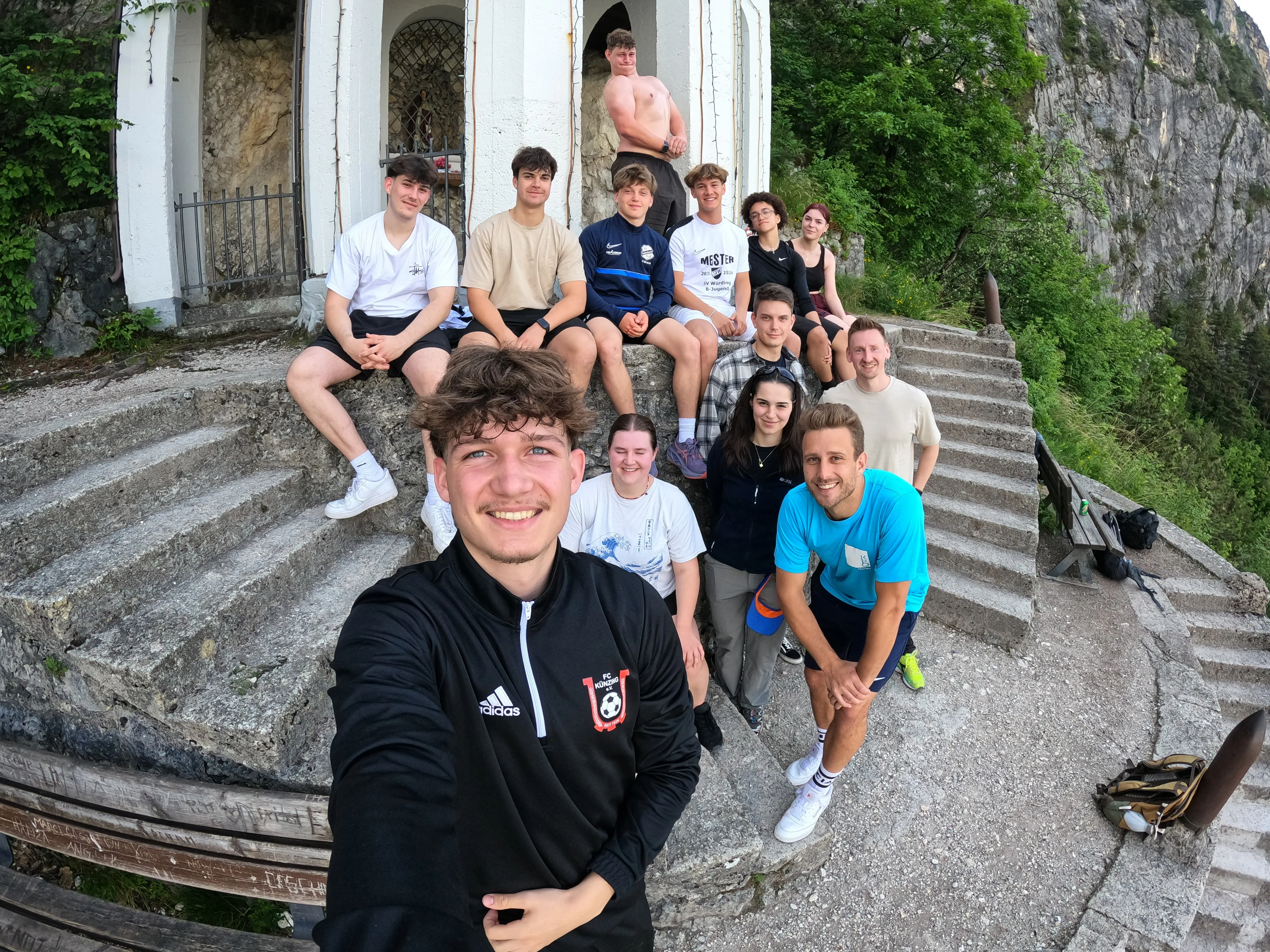 Gruppe junger Leute macht ein Selfie bei einem gemeinsamen Outdoor-Ausflug in den Bergen – Teamgeist bei ZF erleben.